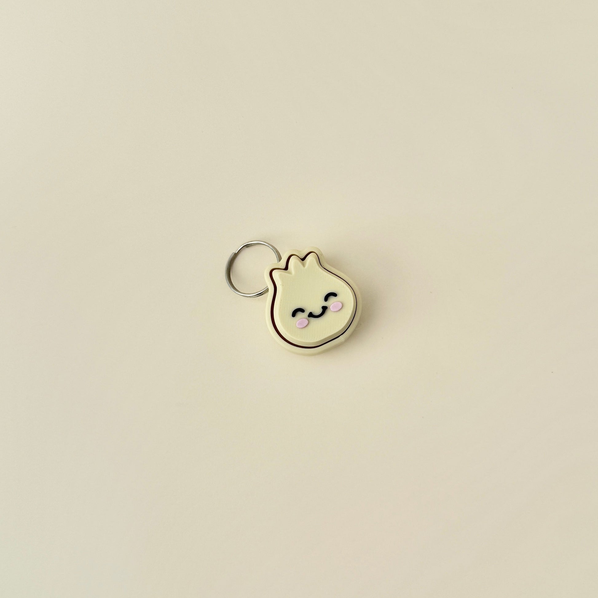 A cute, small dumpling clicker with a keychain, featuring a soft press mechanism that makes an audible clicking noise.