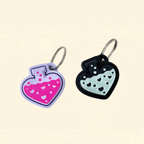 Collection of potion bottle clicker keyrings with black and lilac designs, featuring shimmery liquid and heart patterns.