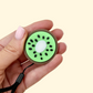 Fruit-themed clicker with wrist strap for bags or lanyards; great for grounding on the go.
