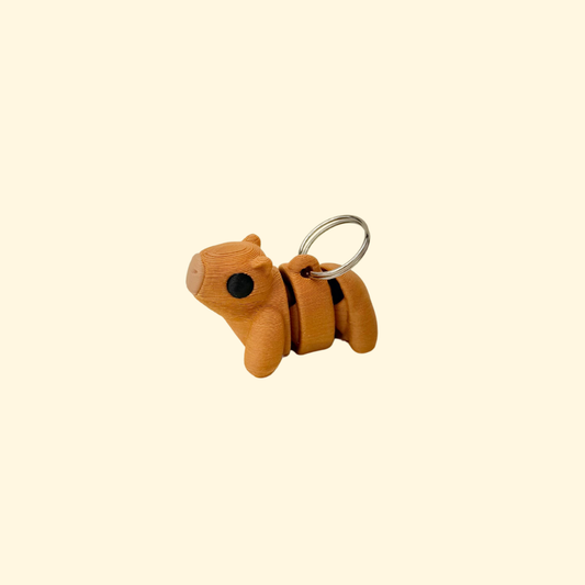 Compact capybara charm-style fidget on a metal loop, made for quick-access sensory support on lanyards.
