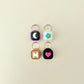 Four keychains with different designs on a beige background