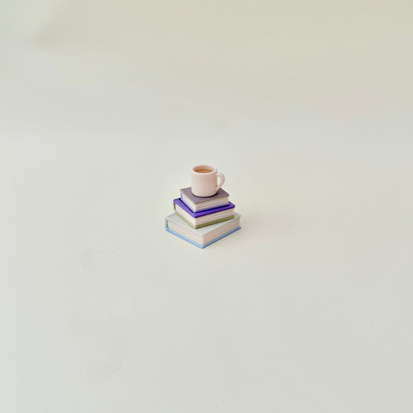Book lover’s fidget clicker with mug button; 4 cm size, textured spines for tracing, quiet option for classrooms and offices.
