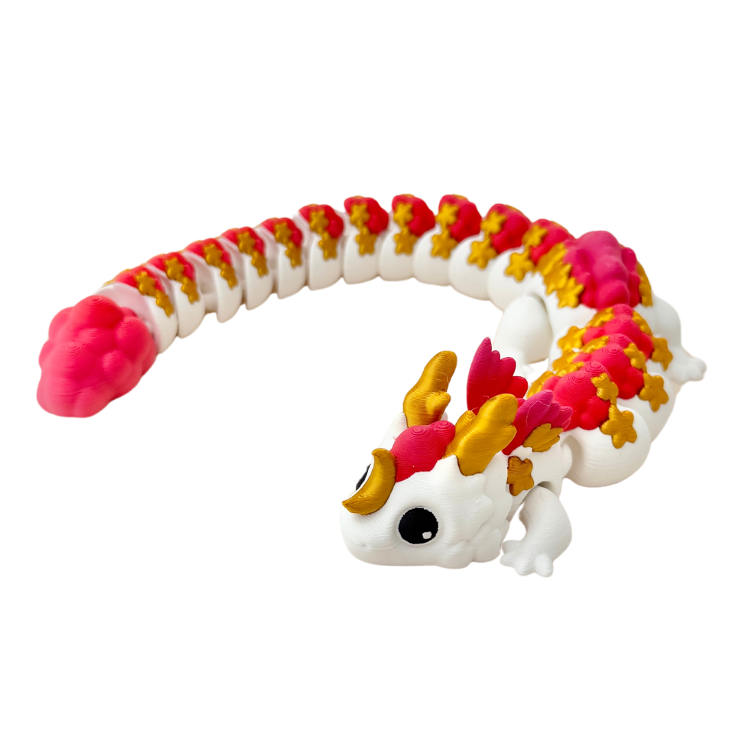 Lunara dragon fidget toy with white body, golden stars, gold horns, and fiery red and pink accents.