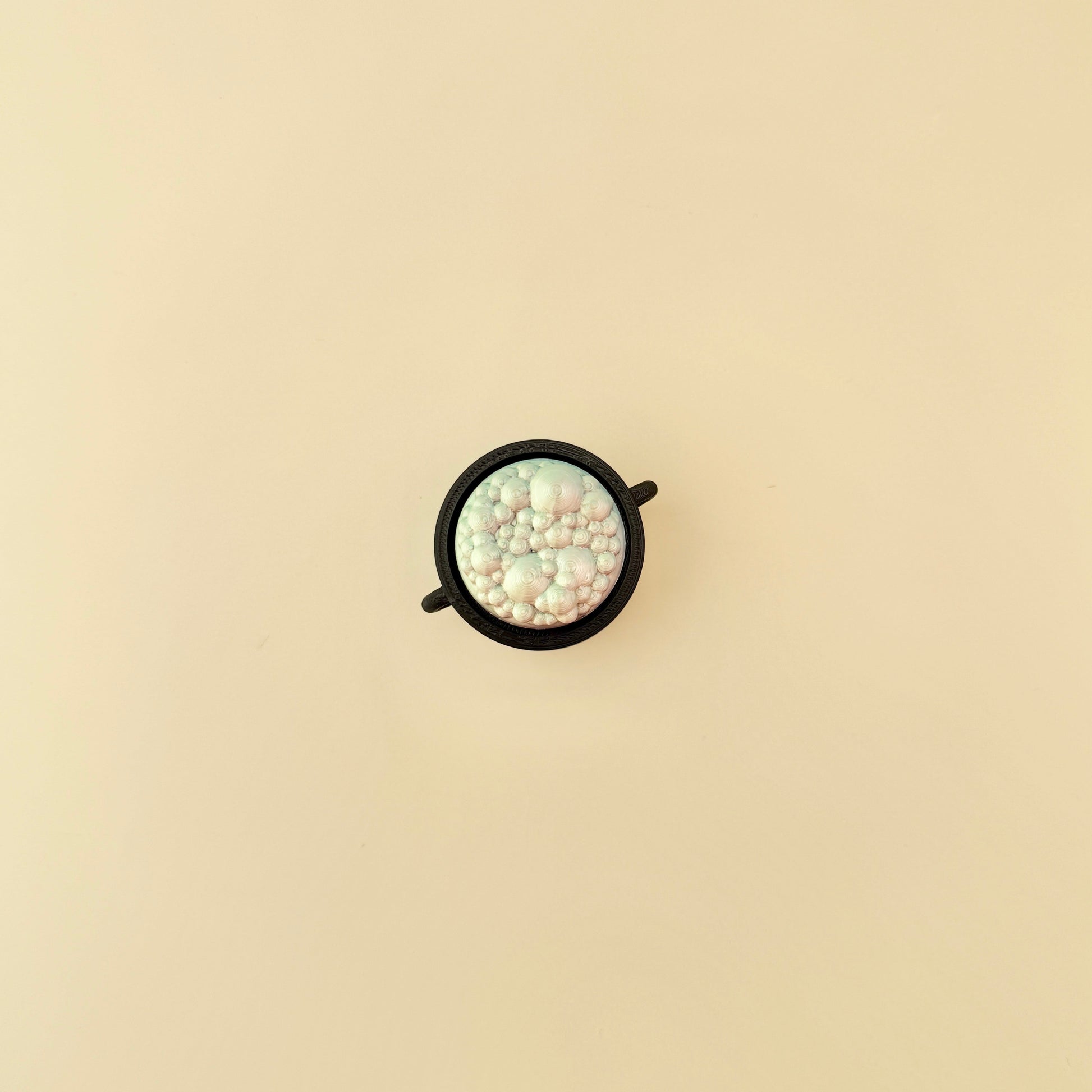 cauldron-shaped sensory clicker with colourful bubble details
