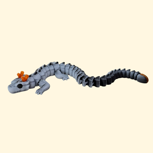 Colour-shift dragon fidget with articulated body in black and white, glitter-gold horn details, quiet desk-friendly movement.
