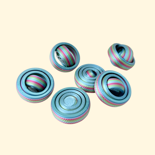 Compact rainbow-coloured fidget spinner with a textured outer ring, designed for smaller hands.
