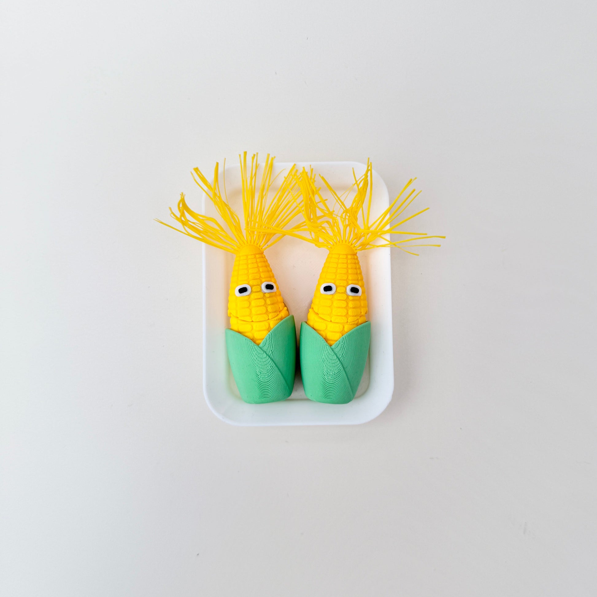 Palm-size corn with a hinged bite that reveals teeth and a tongue for playful stimming.
