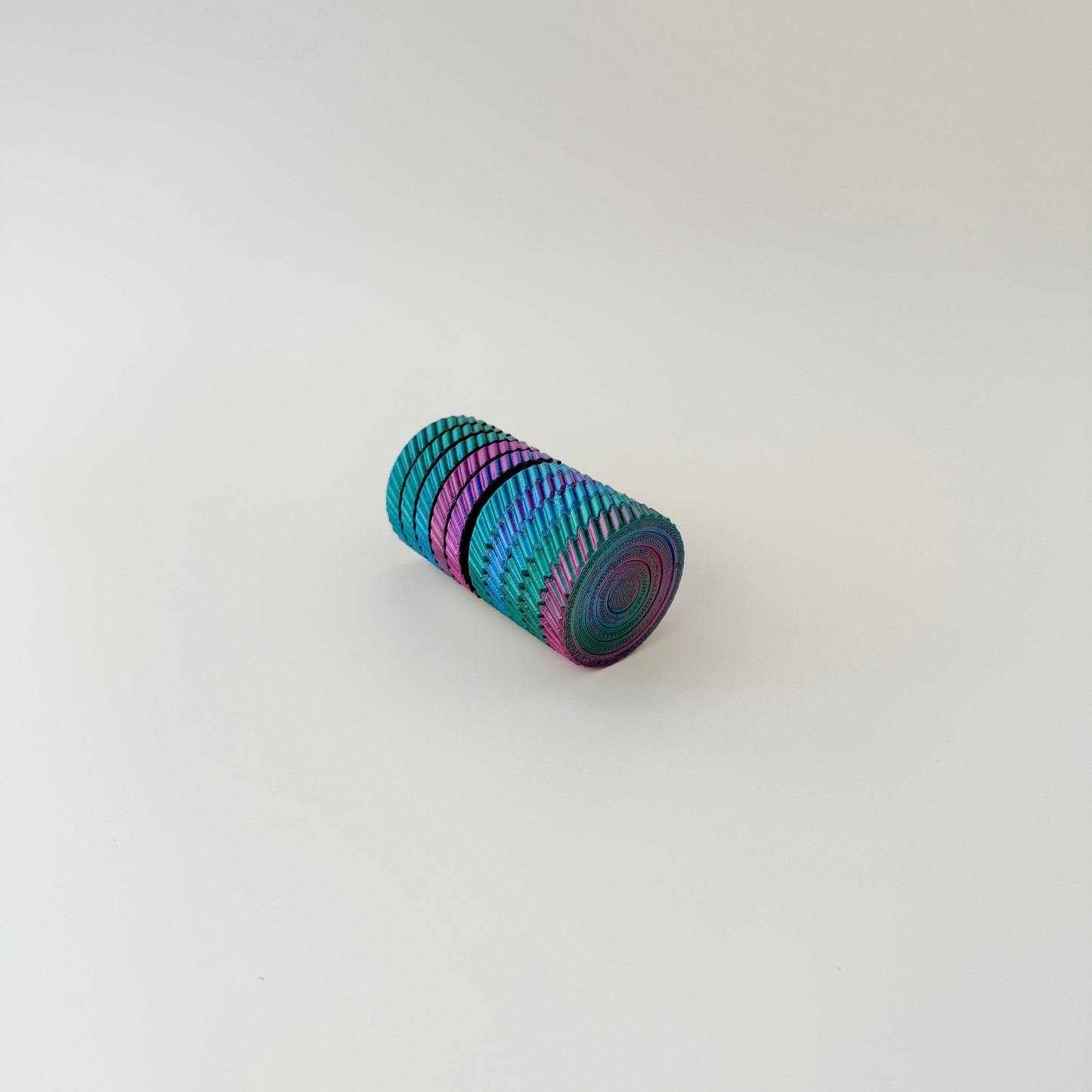 A 7cm tall spinning fidget toy with colourful layers that twist and rotate.