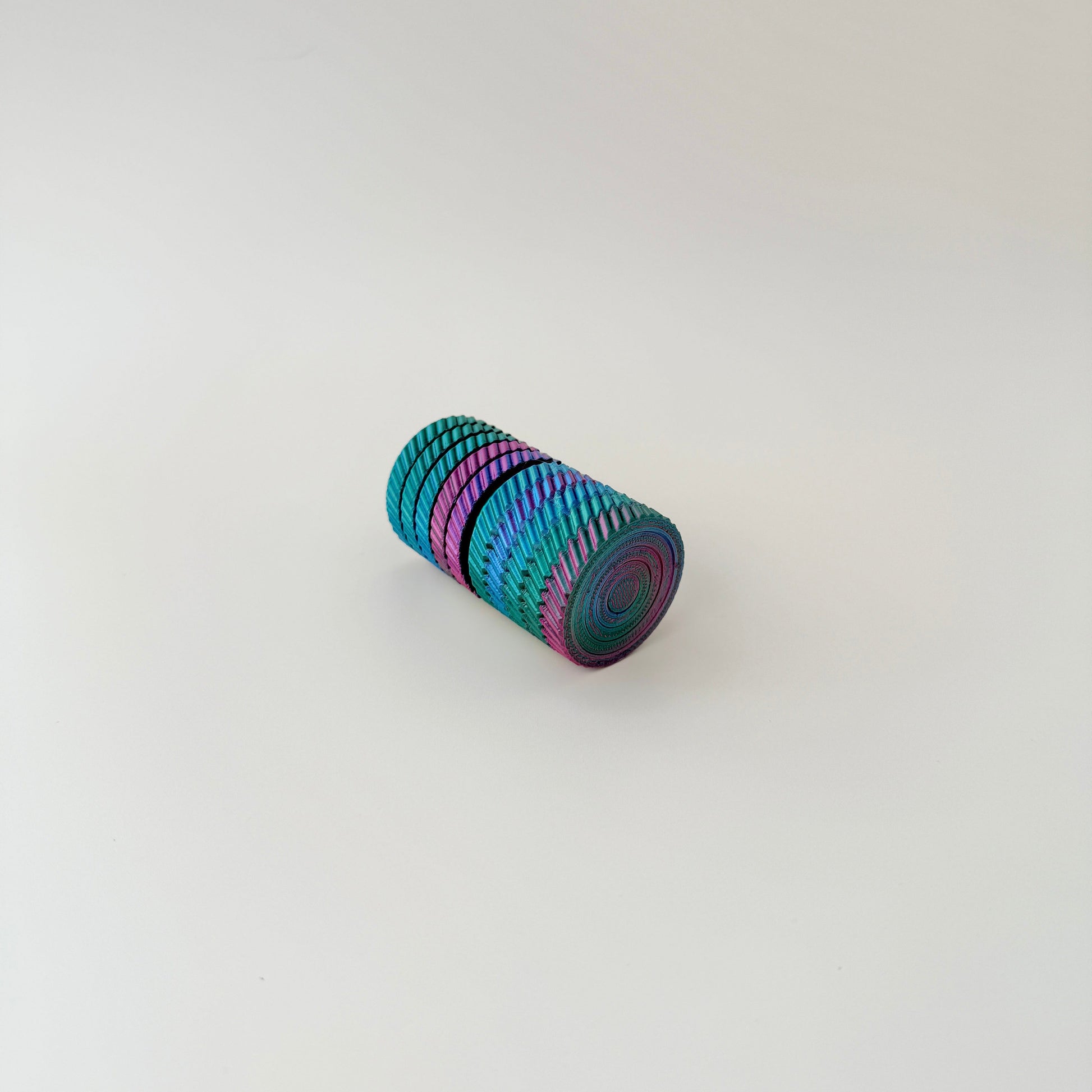 A 7cm tall spinning fidget toy with colourful layers that twist and rotate.