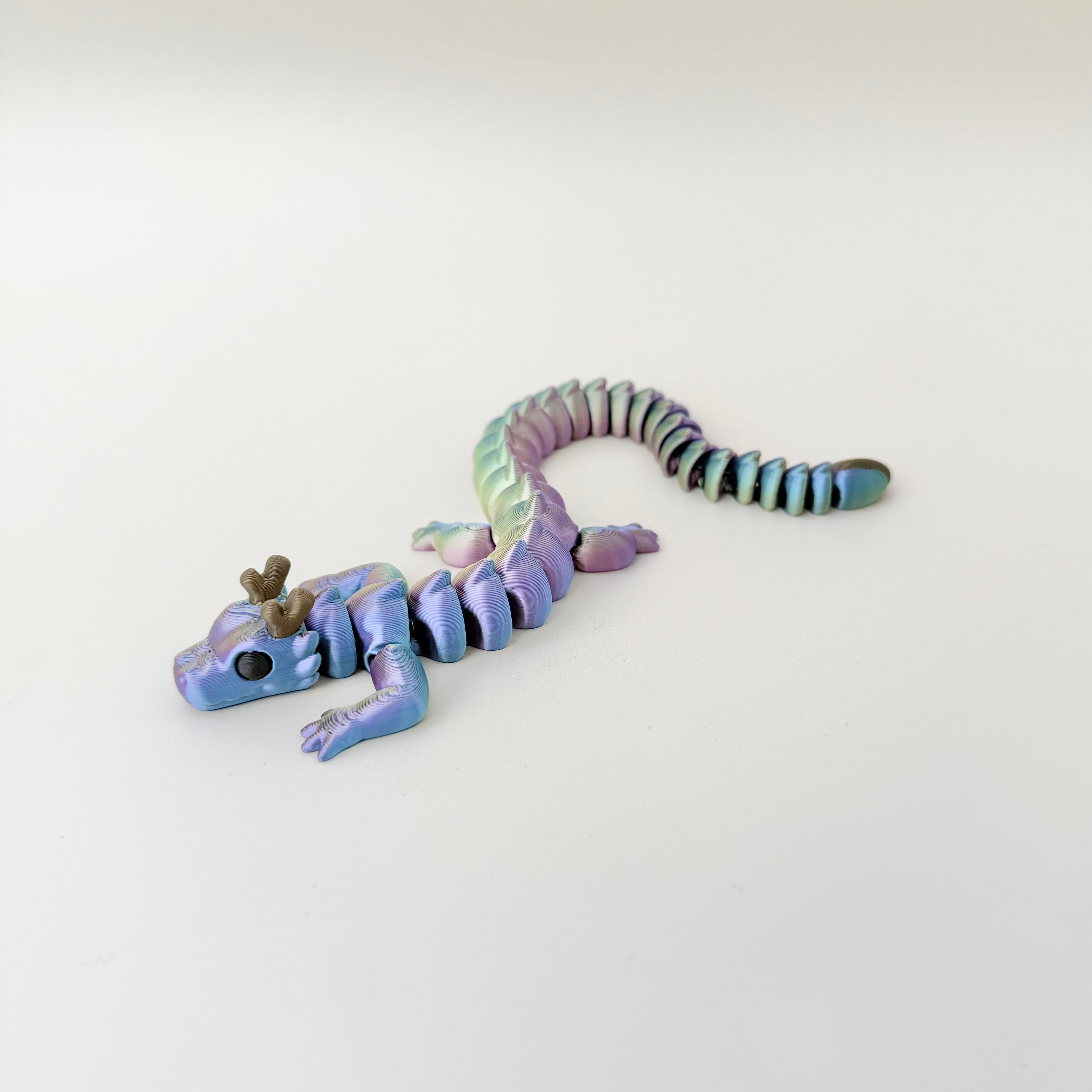 Articulated dragon fidget with flexible body and tail for calming, tactile movement and satisfying desk stimming.
