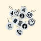 A close-up of NFC keyrings in black and white, featuring various icons like a heart, phone, and Wi-Fi symbol, highlighting their versatility for programming and use.