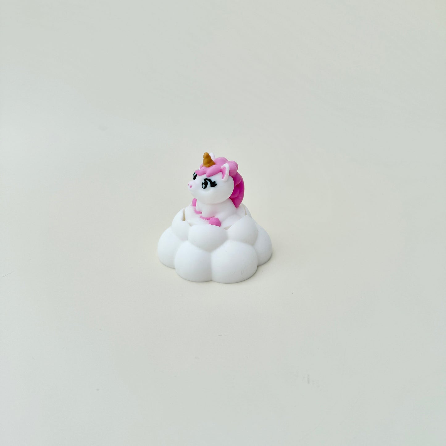 White cloud base with pink-and-gold unicorn details for cute desk décor.
