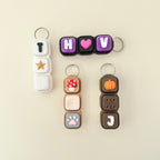 Collection of colorful keychains with various designs on a beige background