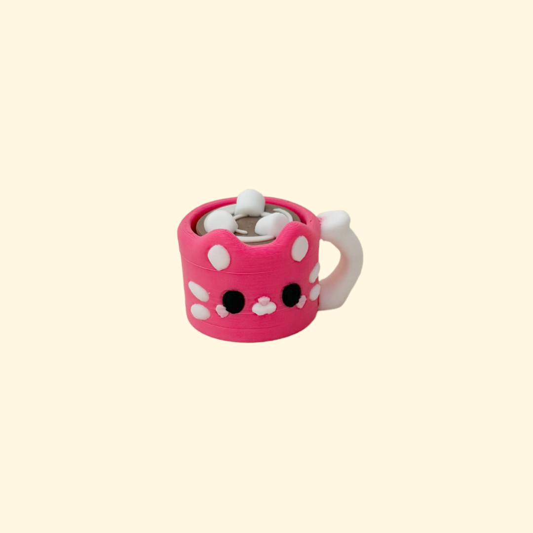 Small pink cat-themed mug fidget with marshmallow button for winter sensory stimming.
