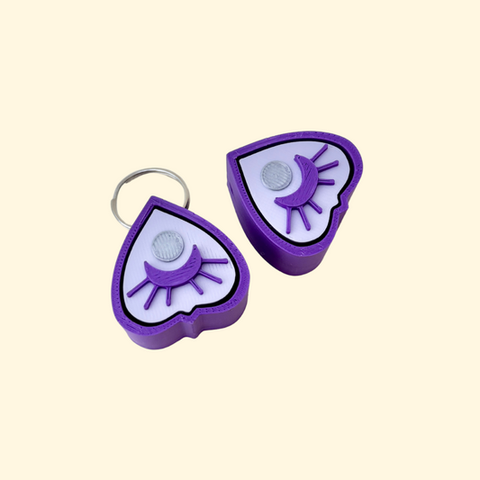 small planchette-shaped clicker fidget with textured top and keyring loop
