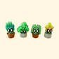 Four mini plant character toys with cartoon eyes and twist-lock pots, each featuring unique plant details and colours.