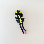 Compact black dragon sensory toy with rainbow details and articulated body, ideal for stress relief.