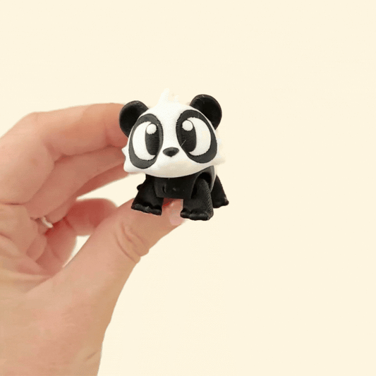 A small, fully flexible panda fidget toy with moveable parts and cute pink paw pads for sensory play.