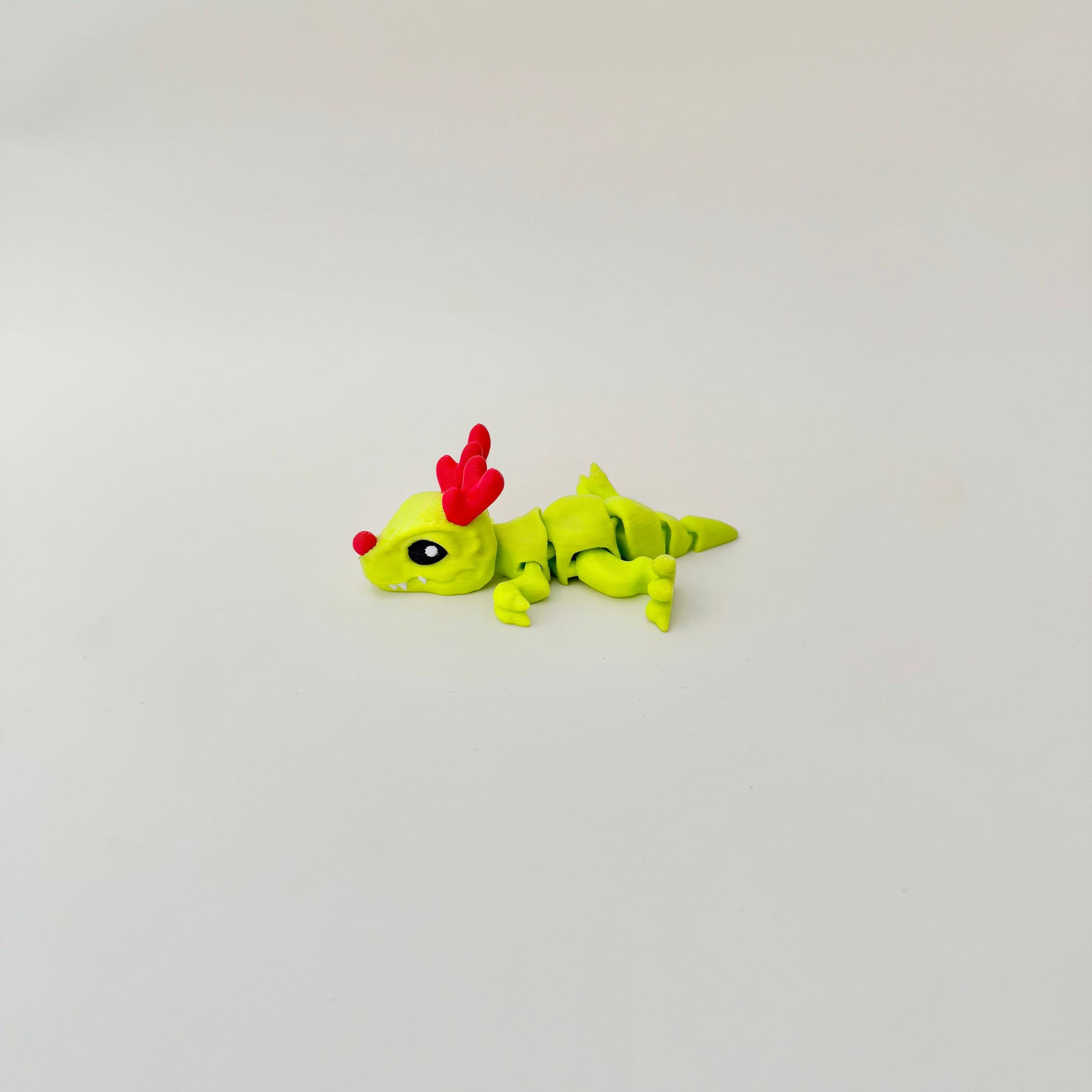 Mini articulated dinosaur fidget toy, stands or lies flat, gentle wiggle motion for calm fidgeting.
