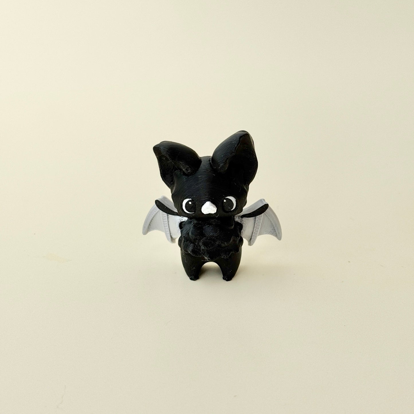 small winged fidget figure designed for grounding and focus breaks; no-click design; tactile textures for thumb tracing
