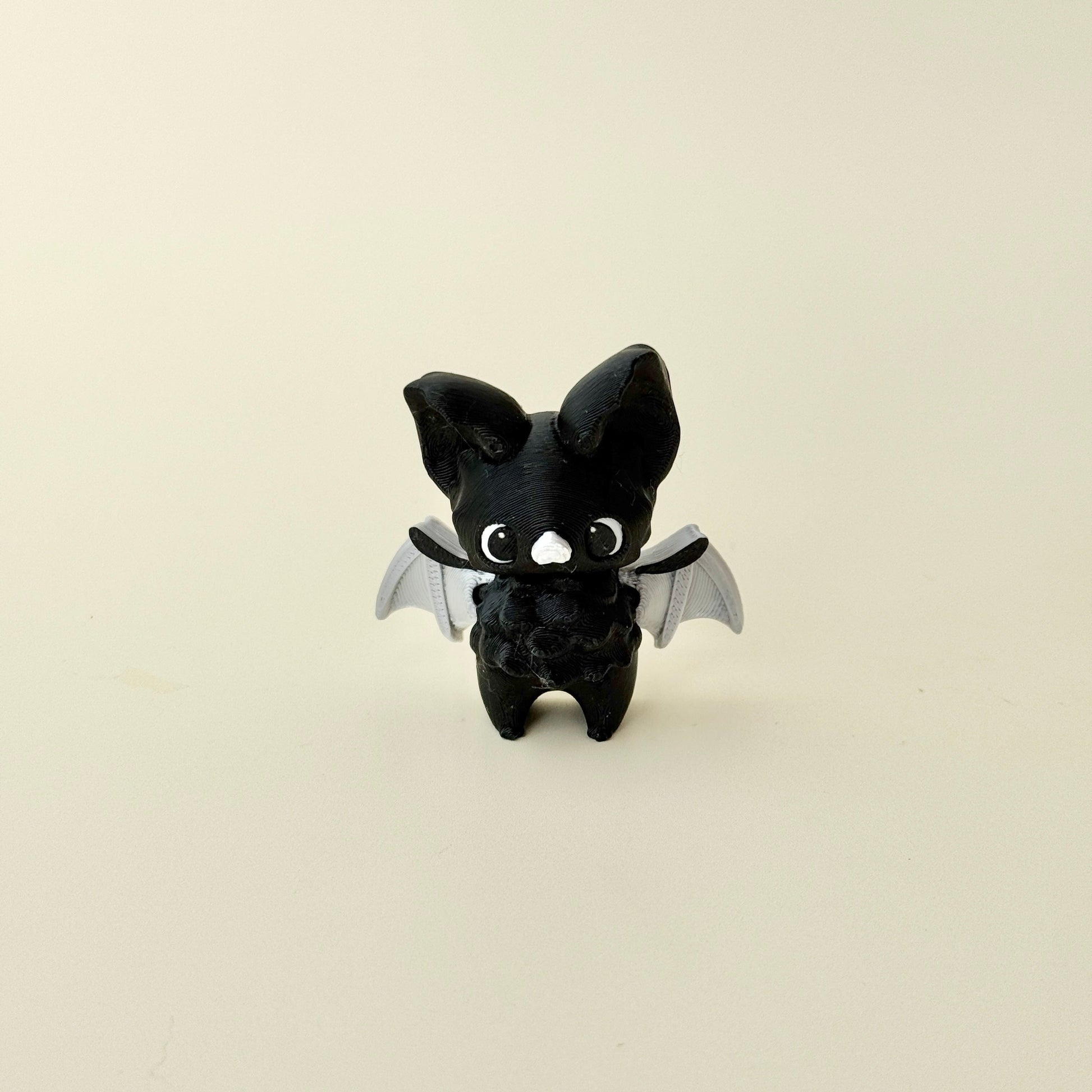 small winged fidget figure designed for grounding and focus breaks; no-click design; tactile textures for thumb tracing

