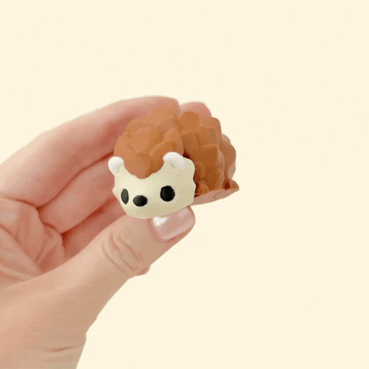 Compact hedgehog sensory toy in gradient rainbow and natural brown and beige tones, fully articulated for calming play.