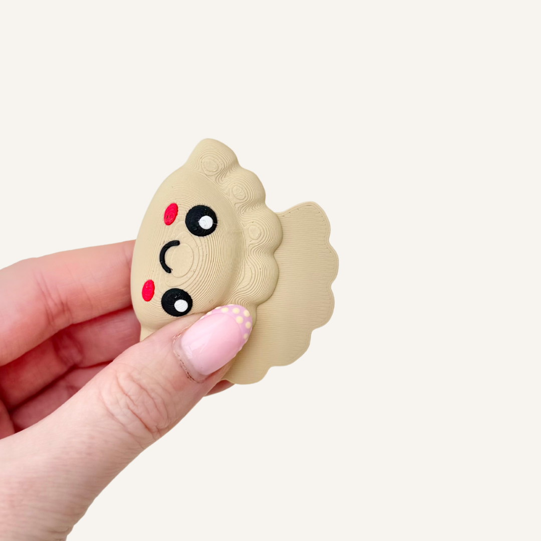 Small dumpling shaped swing magnet fidget with keychain attachment designed for easy one hand movement and gentle magnetic clack.
