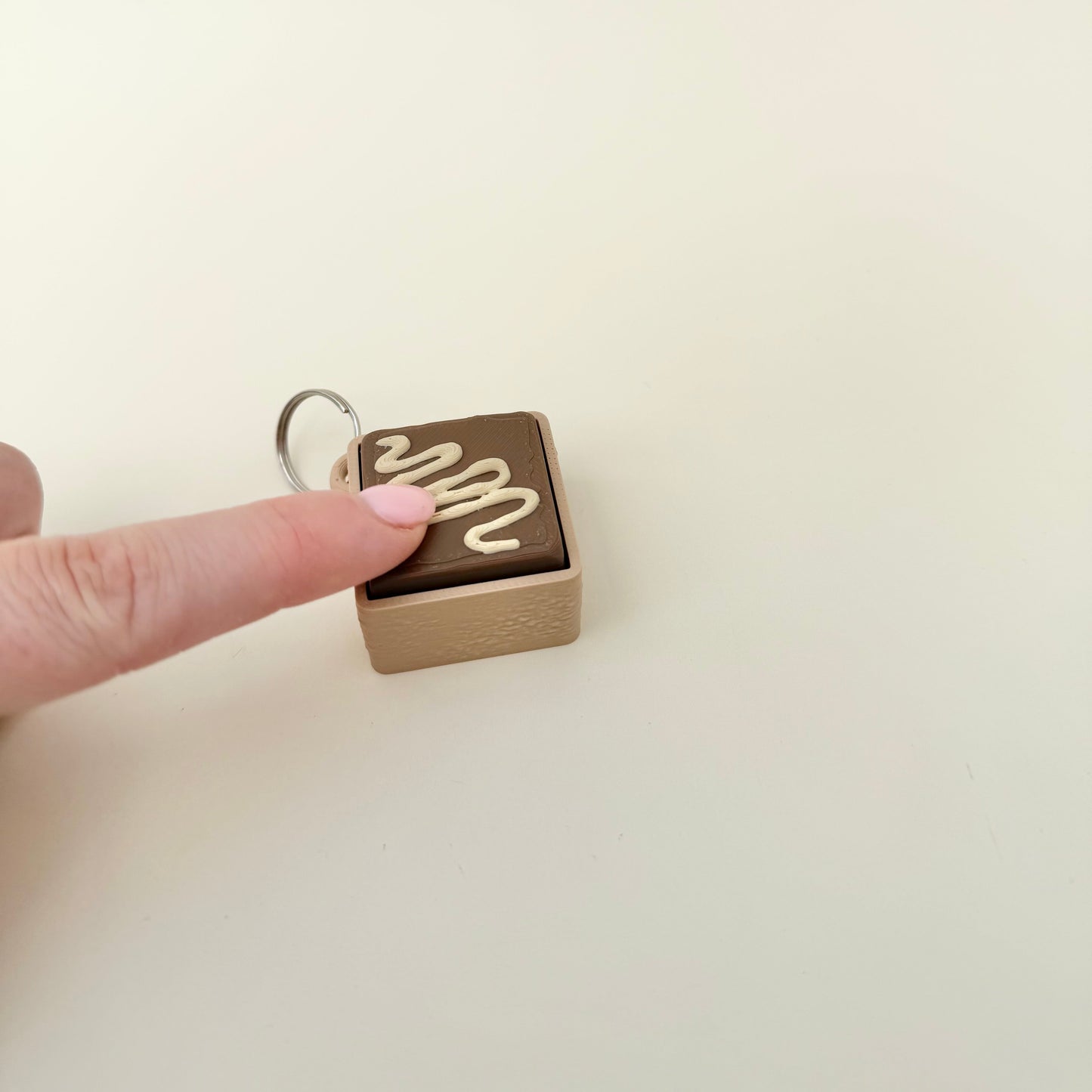 Compact novelty clicker fidget inspired by chocolate fudge, ideal for sensory play and on-the-go stimming.
