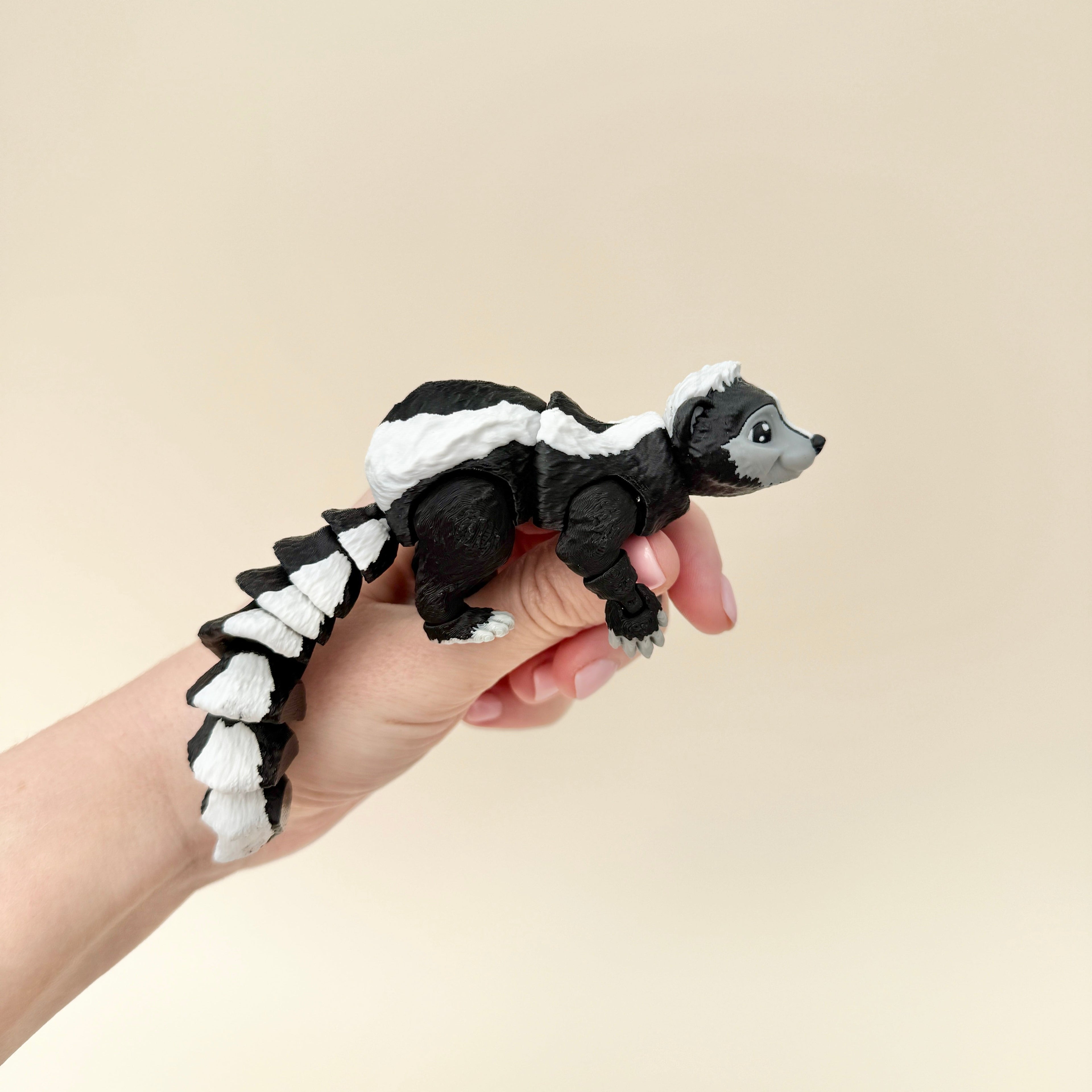 A realistic skunk toy with a poseable tail and movable parts, great for fidgeting, sensory play, and display.