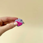 Front view of a potion bottle keyring fidget toy with liquid design and heart accents, available in black or lilac.