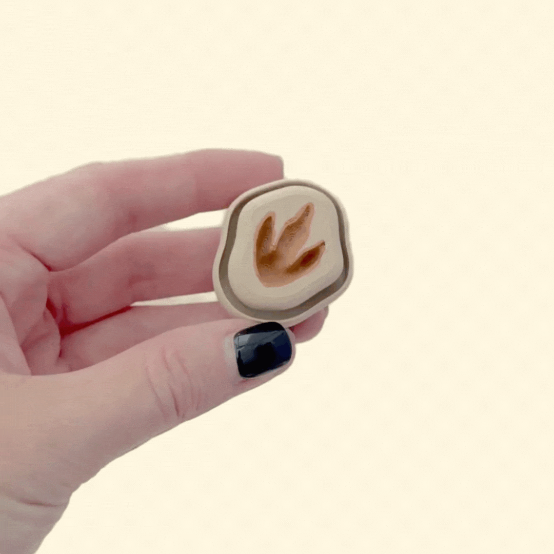 Little dinosaur footprint desk fidget with raised centre for thumb presses and tracing.
