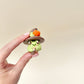 Frog fidget with a pointed hat decorated with a small pumpkin and leaves.
