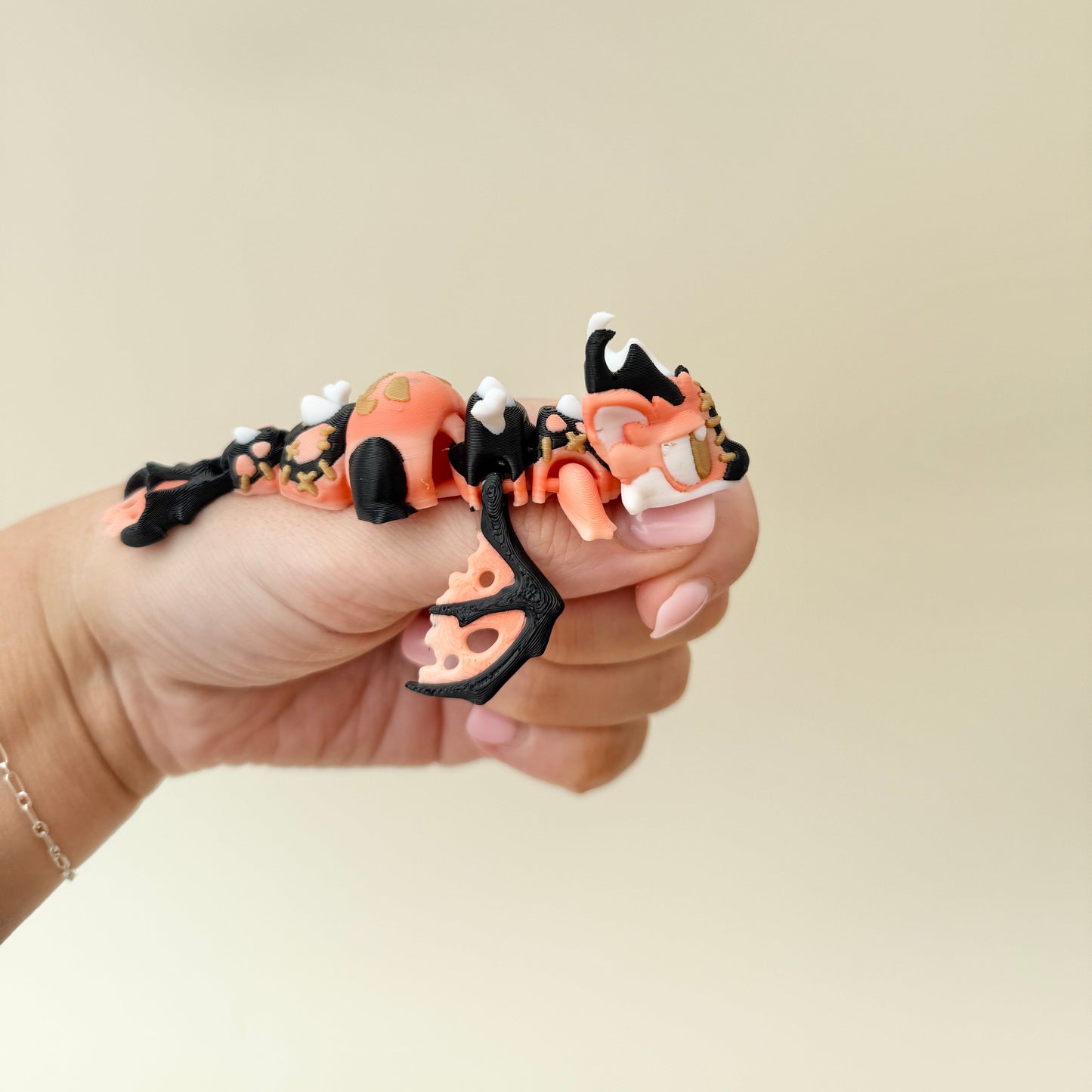 Seasonal dragon with a pumpkin panel on its back and contrasting black limbs.
