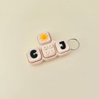 Keychain with letters 'GO' and 'J' on a beige background