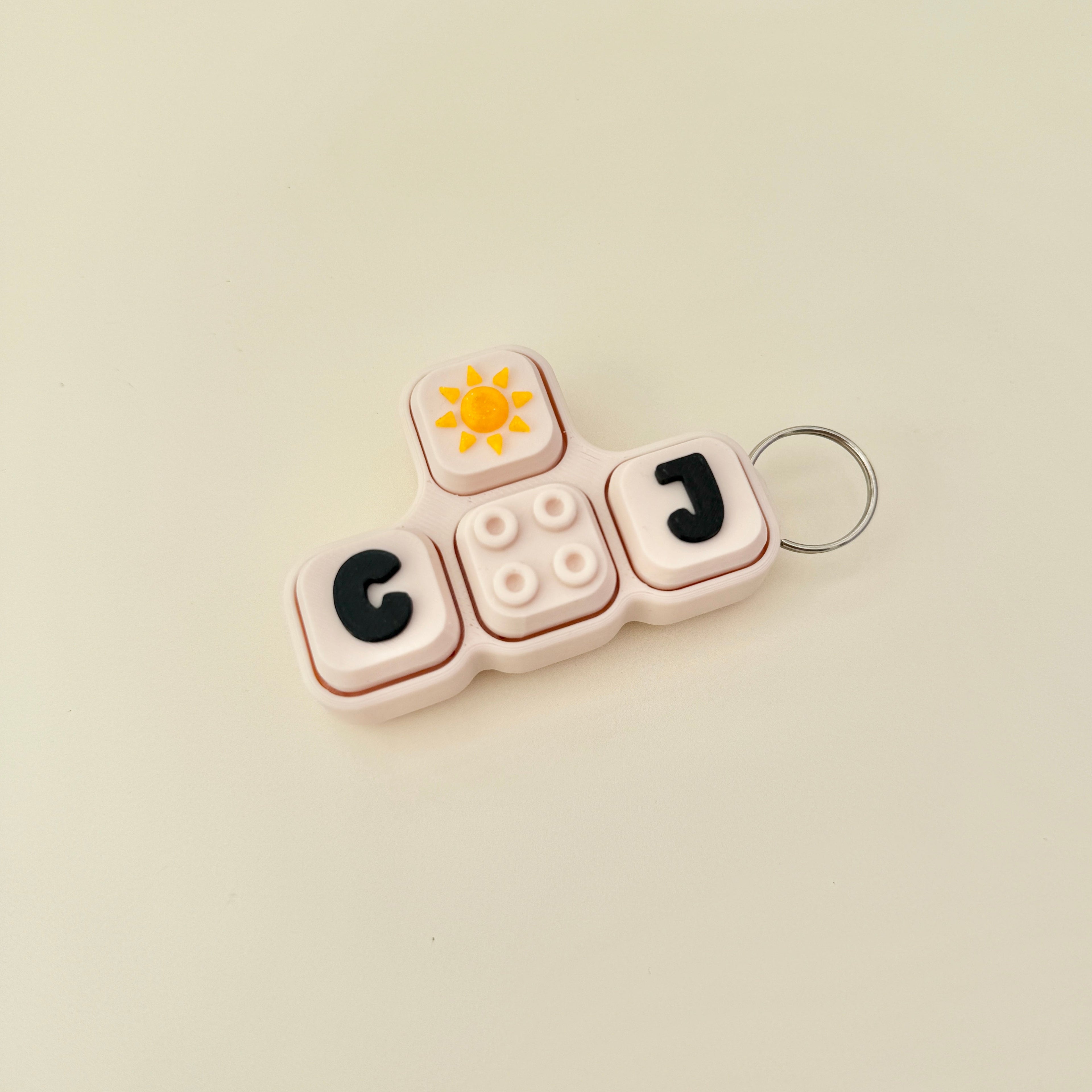 Keychain with letters 'GO' and 'J' on a beige background