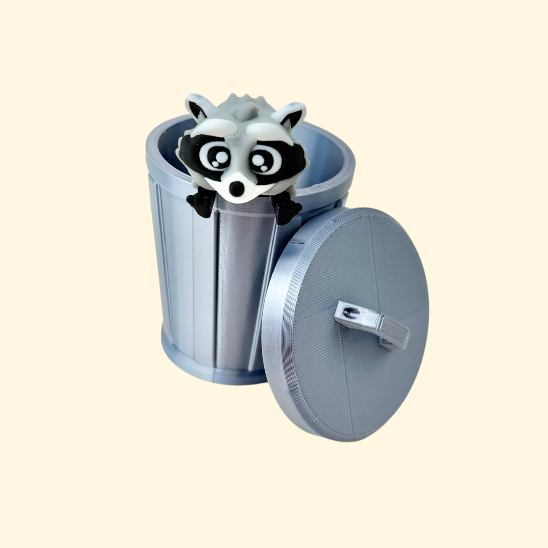 Moveable raccoon toy peeking out of a grey trash can, perfect for fidgeting and display.