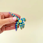 A lightweight sensory fidget with translucent rainbow colouring and soft textured dots.
