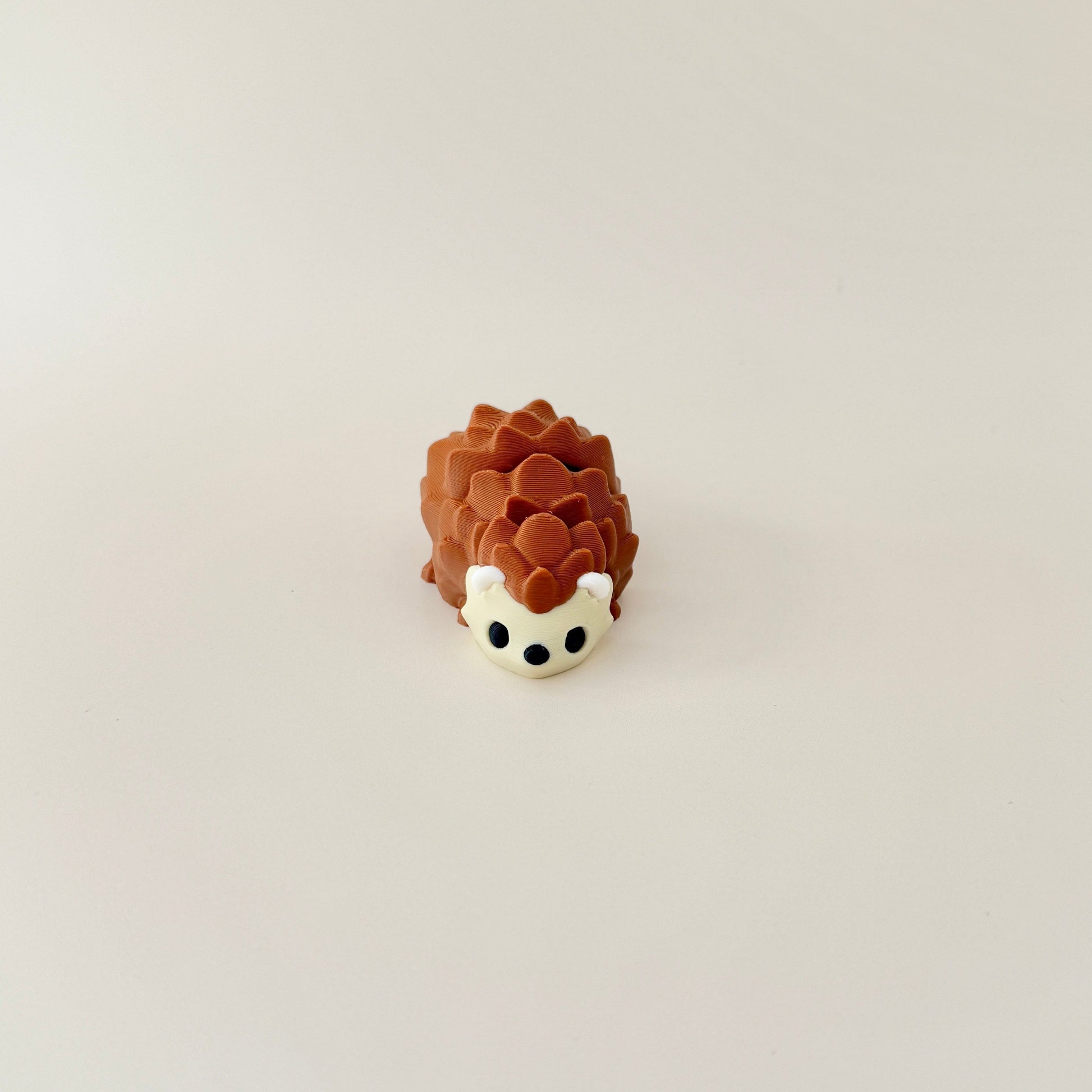 Brown and beige hedgehog fidget toy featuring a flexible, articulated body for stress relief.