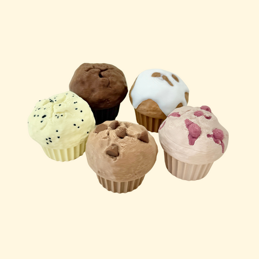 Five small dessert-themed clicker toys in various muffin flavours, textured for sensory use.
