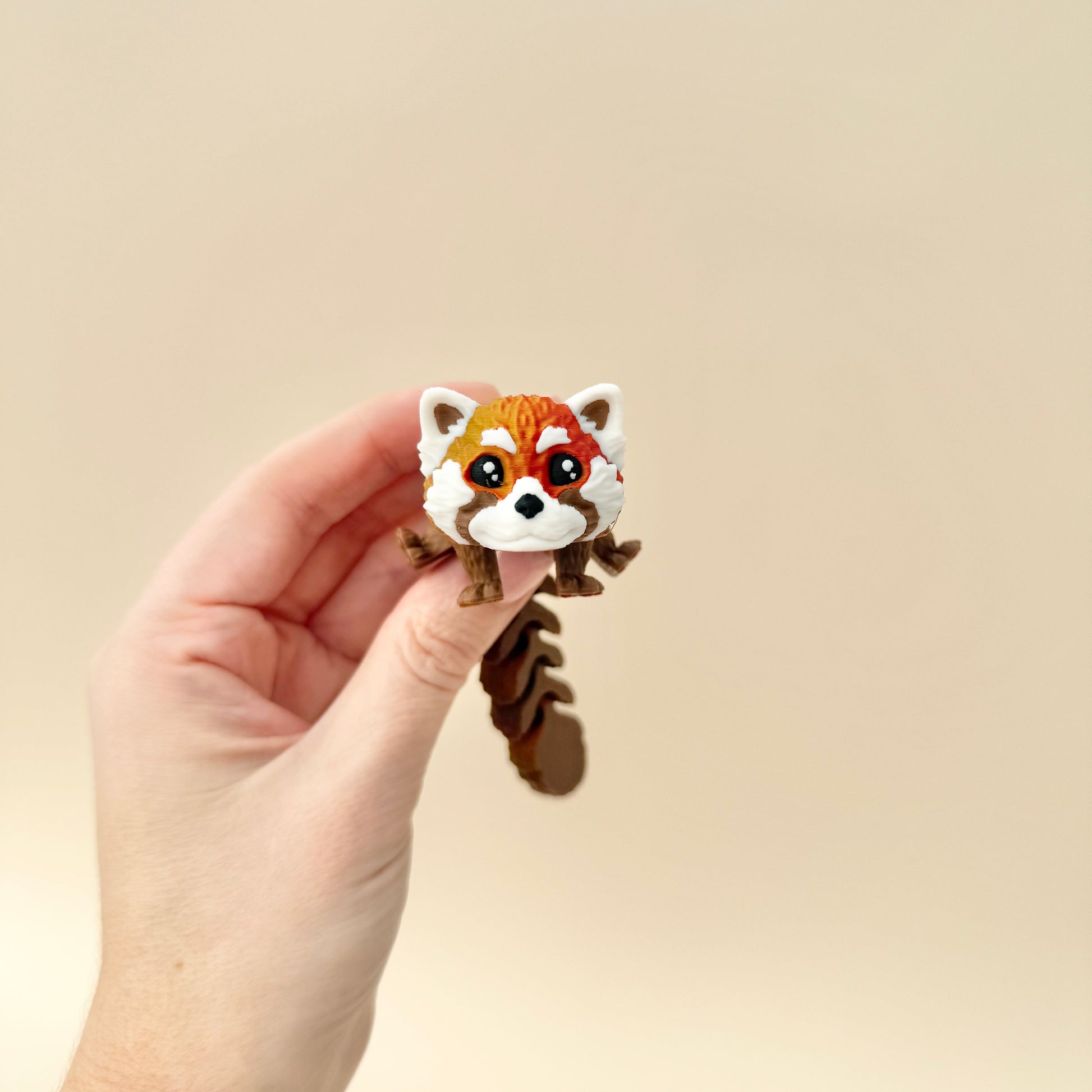 Lifelike red panda toy with a fully flexible design and a shimmering red and brown finish.