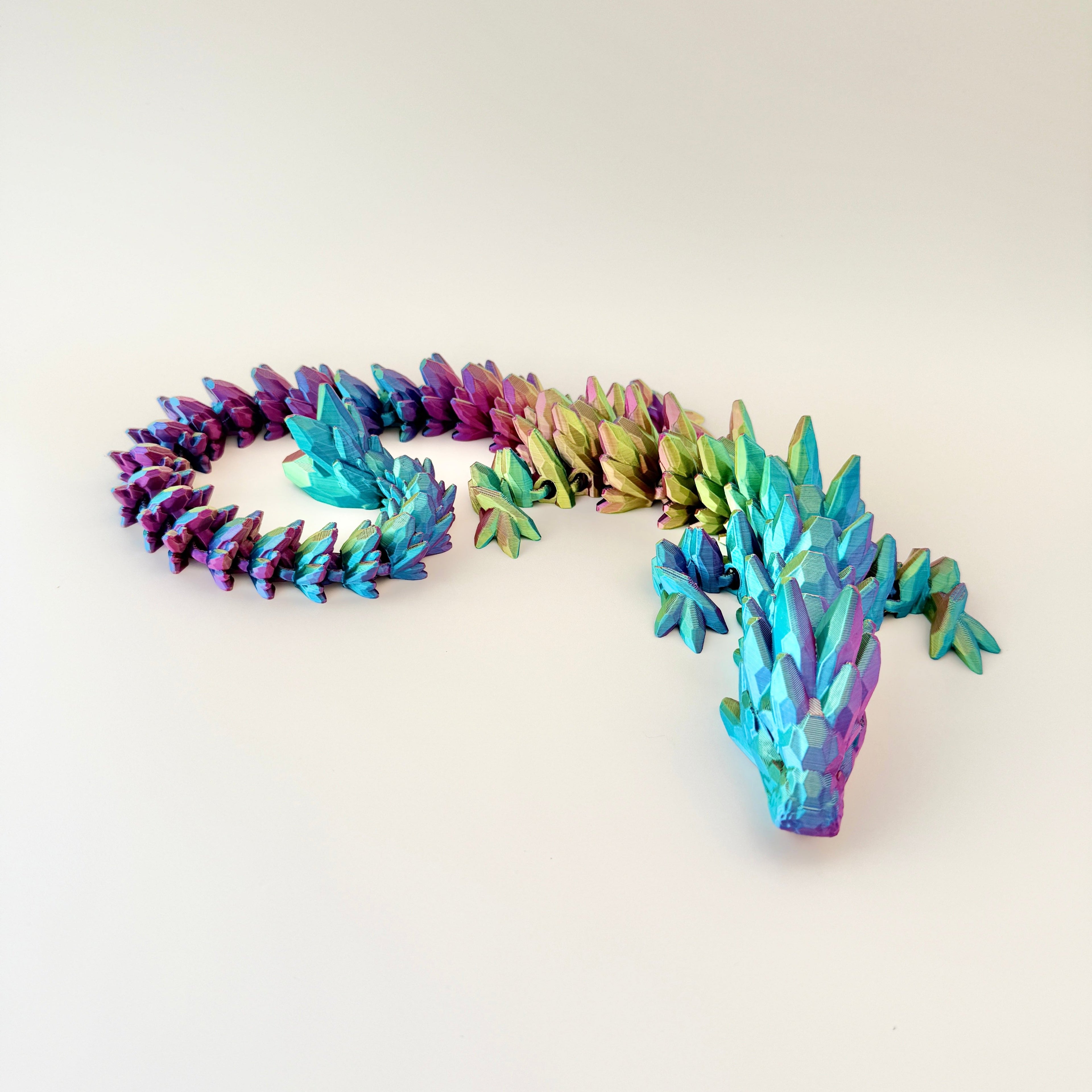 Crystalborne Dragon fidget toy featuring a light-changing filament with red, blue, and gold hues, designed for tactile engagement.