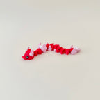 Compact red-and-pink articulated snake fidget with soft texture and heart tail; great pocket sensory tool for fidgeters.
