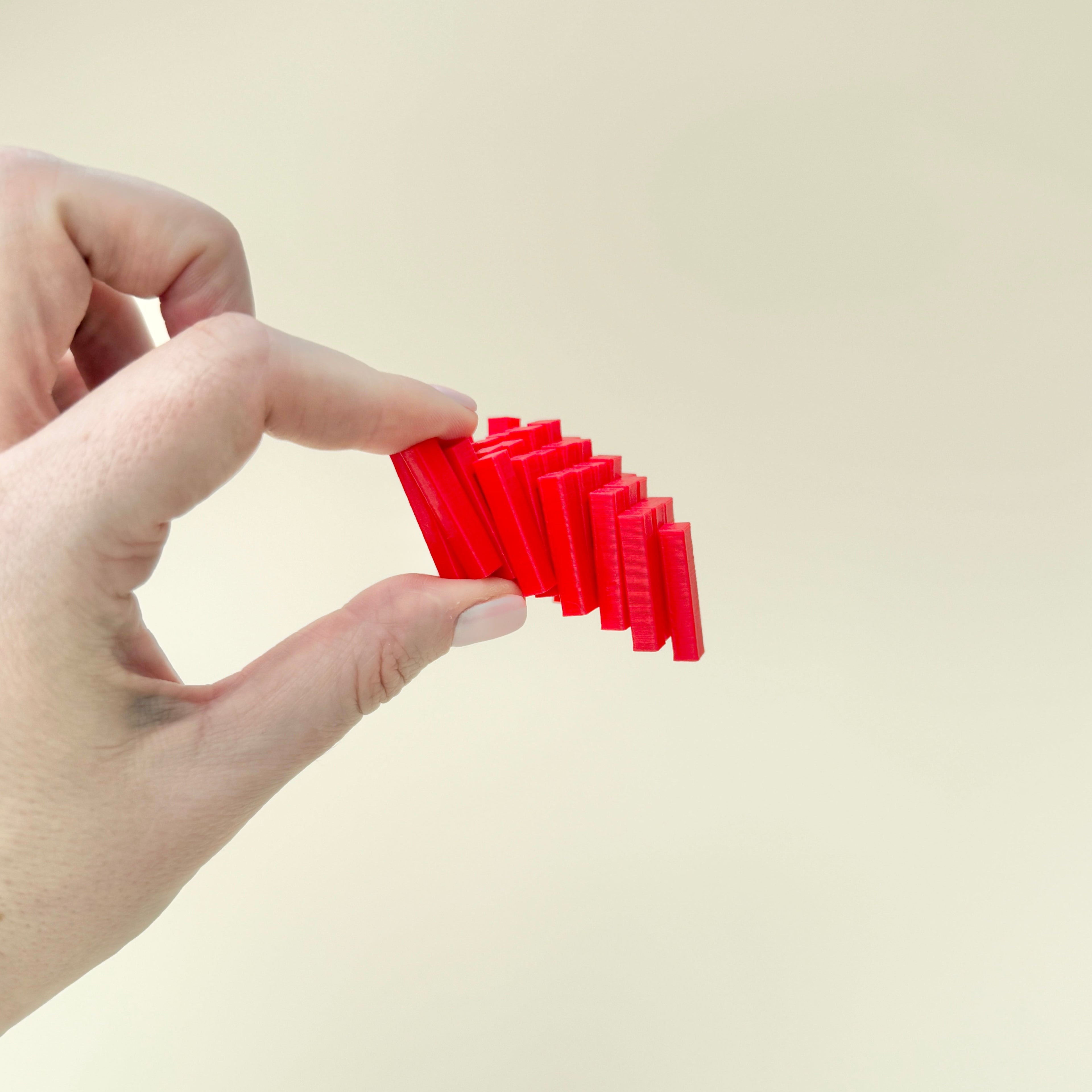 Bright red FlexiHeart fidget toy with a unique block design that slides for sensory play.