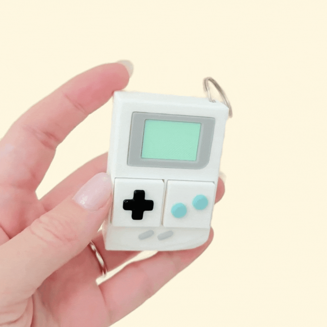 Nostalgic clicker toy inspired by classic handheld gaming devices.