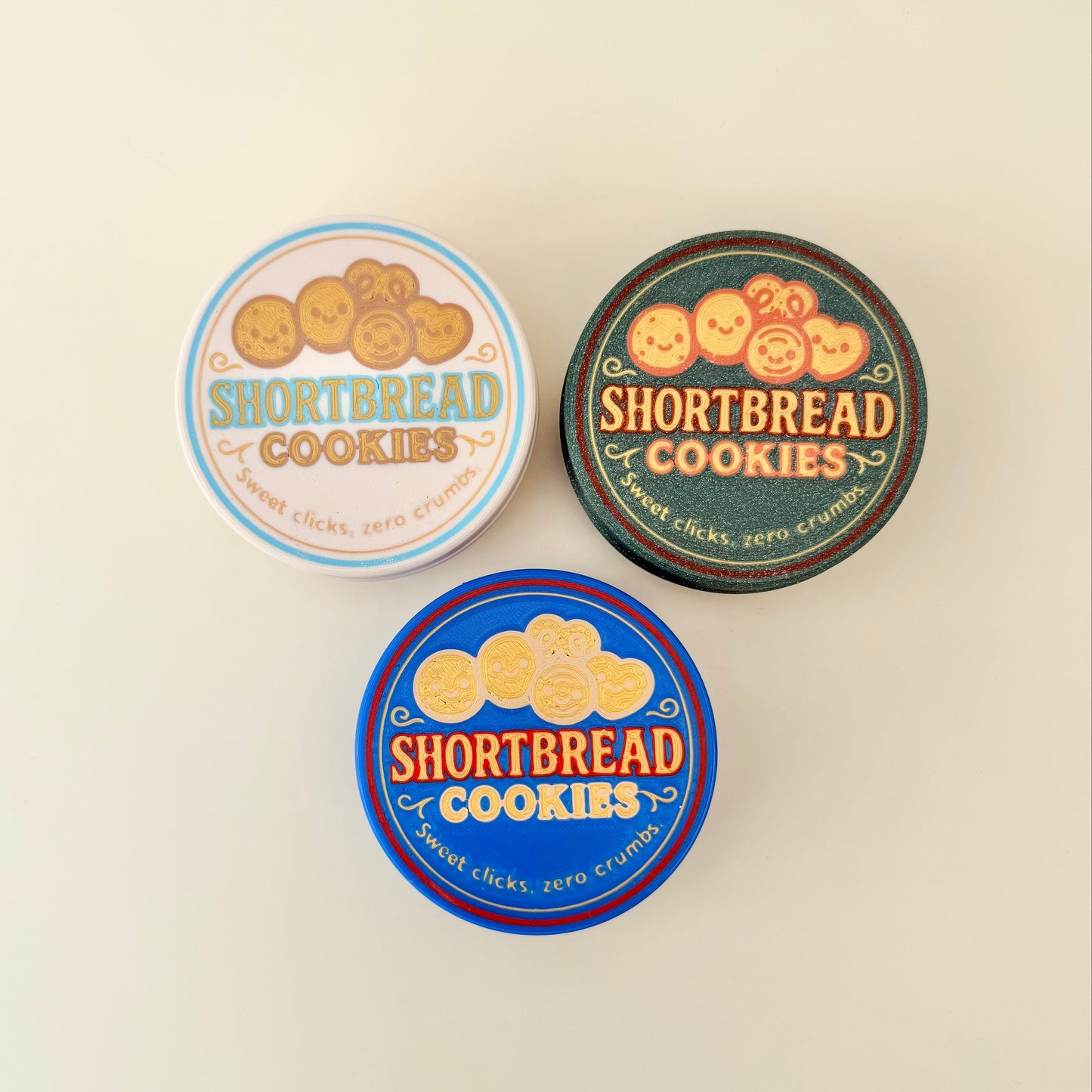 Hard plastic tin with removable lid and classic print; contains multiple tactile clickers for repetitive, calming input.
