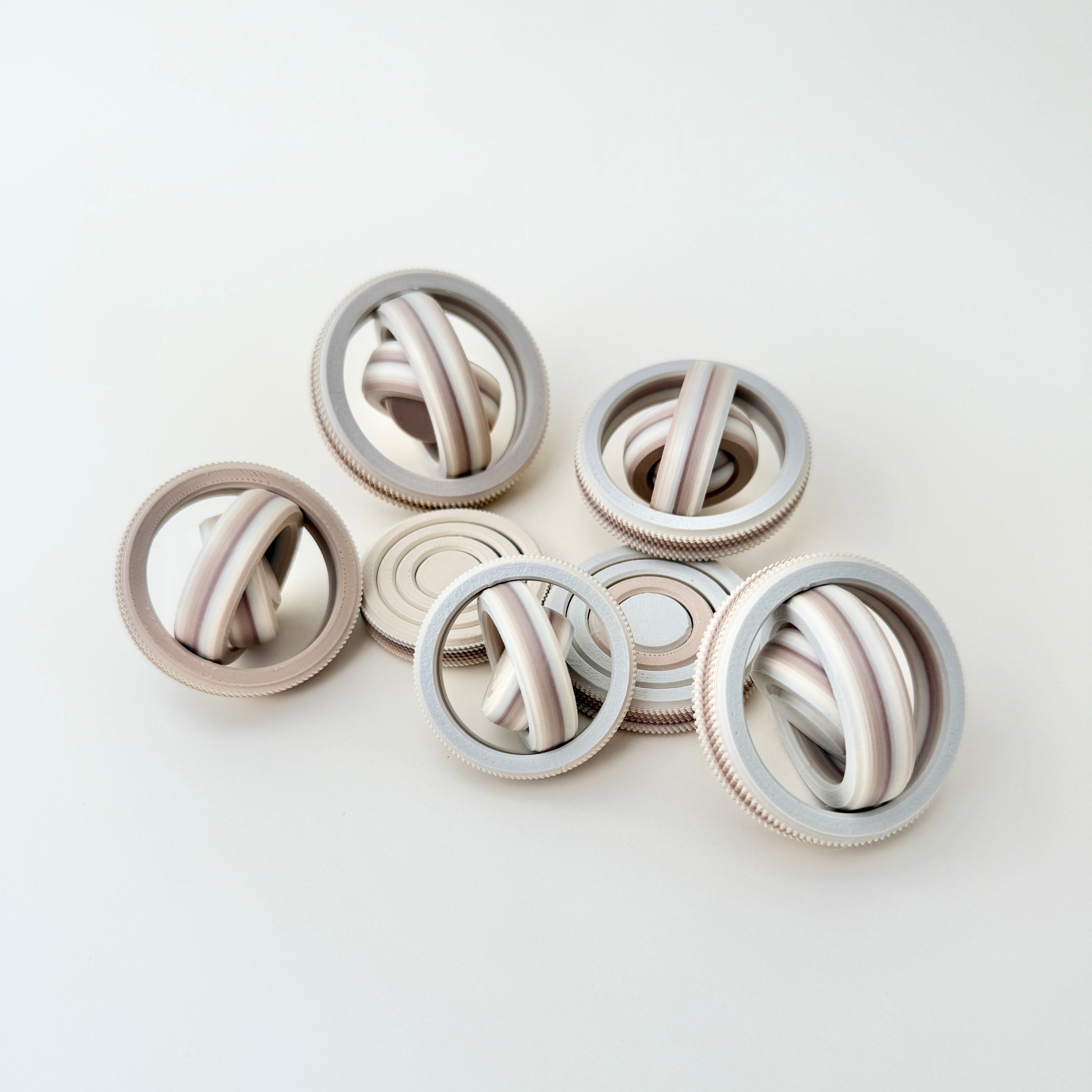 A compact and portable fidget spinner with a neutral colour gradient, perfect for discreet use.