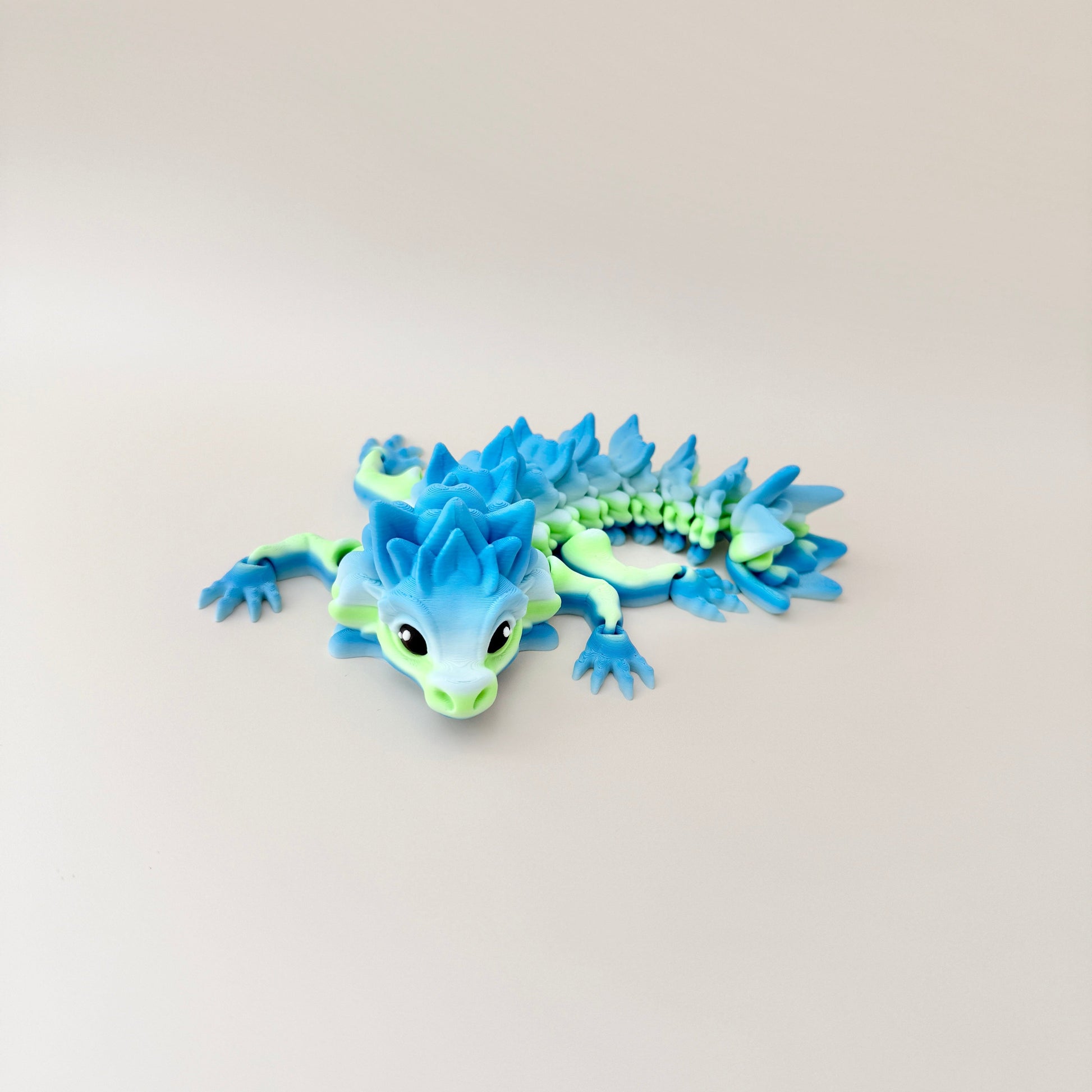 Flexible dragon fidget toy with a bold green and blue gradient, ideal for fidgeting and sensory engagement.