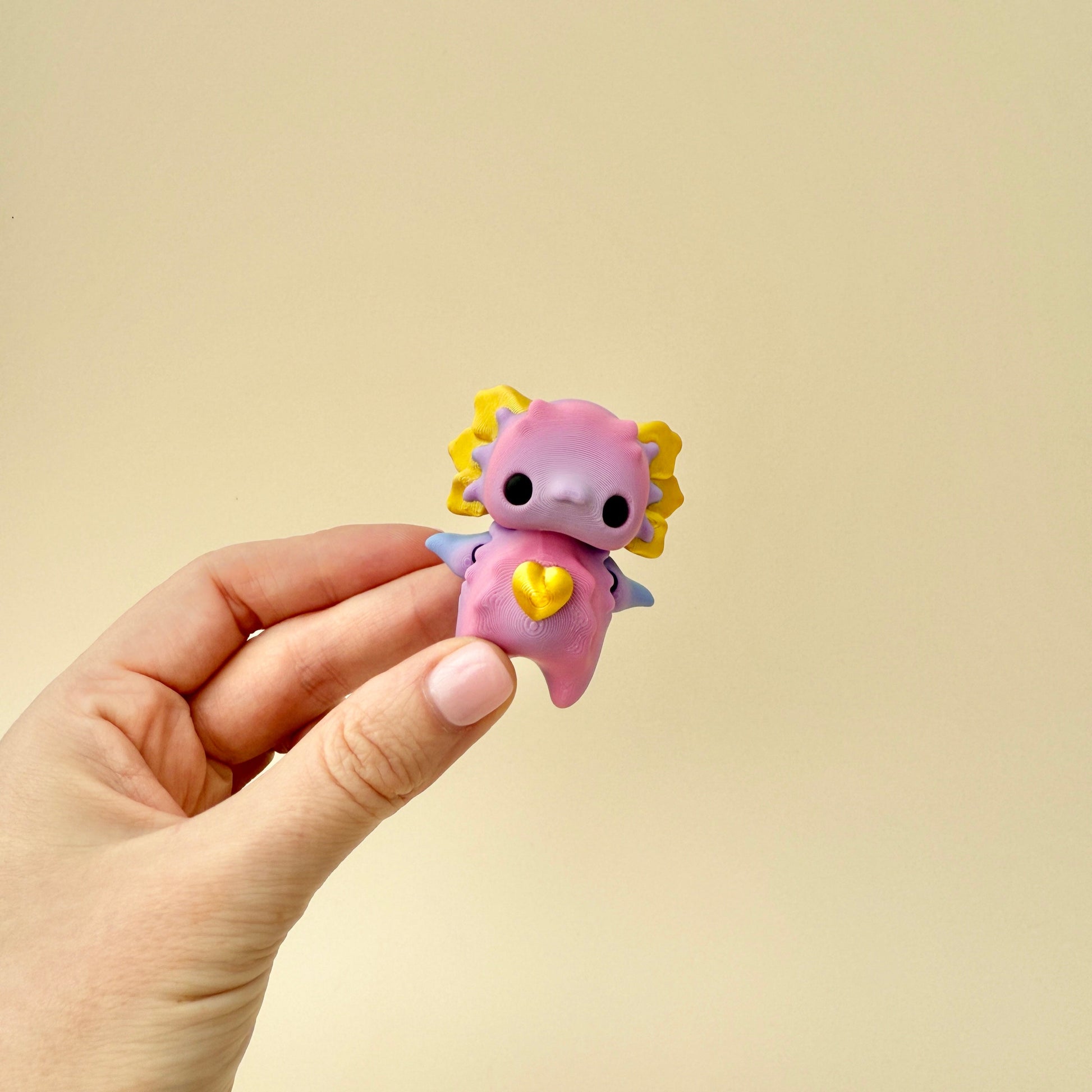 A handheld fidget toy in pastel and metallic colours, designed for calming sensory play.
