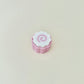 Small sensory clicker with a ribbed base and swirl top.
