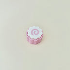 Small sensory clicker with a ribbed base and swirl top.